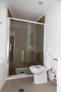 a bathroom with a toilet and a glass shower at Apartamentos Funchal by Petit Hotels in Funchal