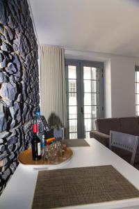 豐沙爾的住宿－Apartamentos Funchal by Petit Hotels，客厅配有带一瓶葡萄酒的桌子
