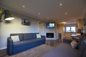 sala de estar con sofá azul y chimenea en Royal Mile Apartment, en Edimburgo