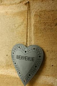 a heart shaped sign on the side of a wall at chambre de madel in Domme