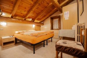 Giacomino Apartment في ليفينو: غرفة نوم بسرير في غرفة بسقوف خشبية