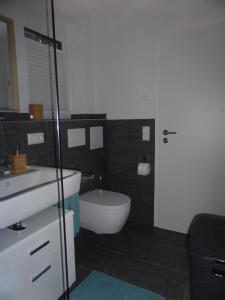 a bathroom with a white sink and a toilet at Ferienwohnung Selina-Sophie in Sehringen