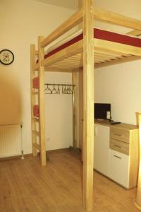 um quarto com uma cama alta e uma secretária em Living in the Box em Berlim