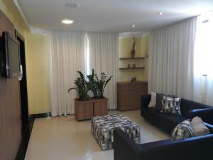 a living room with a couch and a tv at Hotel Sempre Bahia in Salvador