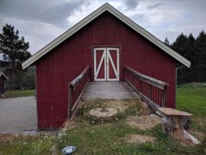 a red barn with a flag on the door at Ivaregga Vinterstua in Tolga