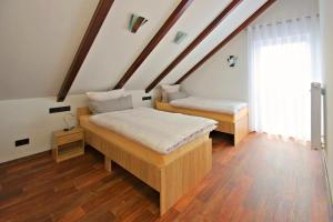 two beds in a room with wooden floors at Ferienwohnung Lausitzer Seenland Freienhufen "Annabell" in Großräschen