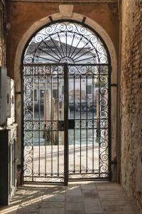 una puerta de hierro ornamentada en un edificio con patio en New apartment in Murano the amazing glass island, en Murano