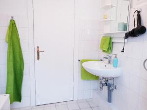 La salle de bains est pourvue d'un lavabo et d'une serviette verte. dans l'établissement 25mn to HH-2BR Kitchen&Netflix, à Elmshorn