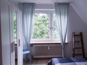 a bedroom with a window and a ladder and a bed at 25mn to HH-2BR Kitchen&Netflix in Elmshorn