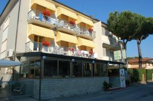 a building with flowers on balconies on a street at Hotel Ristorante La Terrazza in Lido di Camaiore