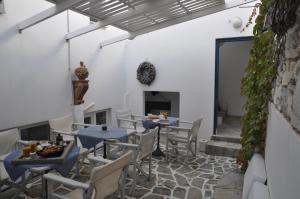 uma sala de jantar com mesas e cadeiras e uma lareira em Vavanos Studios em Naousa