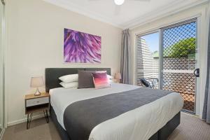 a bedroom with a large bed and a large window at Mayfield Short Stay Apartments in Newcastle