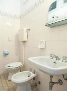 a white bathroom with a sink and a toilet at Hotel Ronconi in Rimini