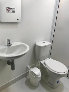 La salle de bains blanche est pourvue de toilettes et d'un lavabo. dans l'établissement Hotel Puerto Azul, à Puerto Berrío