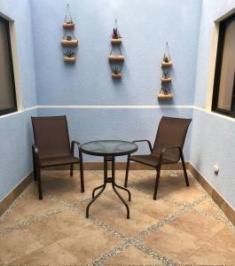2 Stühle und ein Tisch in einem Zimmer mit Regalen in der Unterkunft Hotel Puerto Azul in Puerto Berrío
