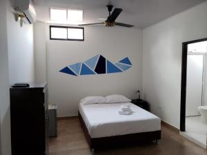 Schlafzimmer mit einem Bett und einem Deckenventilator in der Unterkunft Hotel Puerto Azul in Puerto Berrío