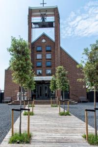 a building with a wooden walkway in front of it at B&B de Petrakerk in Rijnsburg