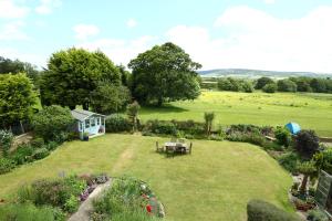 a garden with a table in the middle of a field at Saxon Villa in Robin Hood's Bay