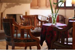 een tafel en stoelen met een vaas met bloemen erop bij Hotel Candelaria Antigua in Antigua Guatemala
