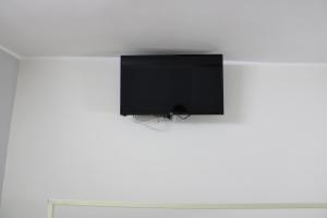 einen Flachbild-TV, der an einer weißen Wand hängt in der Unterkunft Casa Basile 15 in Neapel