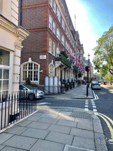 eine Stadtstraße mit einem Gebäude mit einer Flagge darauf in der Unterkunft Buckingham Palace View Apartment in London