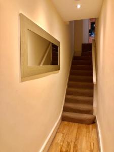 eine Treppe mit einem TV an der Wand in der Unterkunft Buckingham Palace View Apartment in London