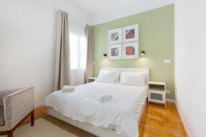 a bedroom with a white bed and a window at Dinostratus House in Athens
