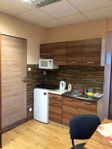 a kitchen with wooden cabinets and a white refrigerator at Ubytovanie Poprad in Poprad