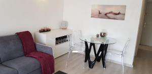 a living room with a table and a chair at Palm beach Cannes Azur in Cannes