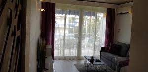 a living room with a couch and a large window at Palm beach Cannes Azur in Cannes
