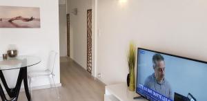a living room with a large flat screen tv on a white wall at Palm beach Cannes Azur in Cannes