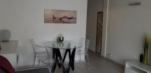 a dining room with a glass table and chairs at Palm beach Cannes Azur in Cannes