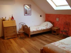 1 dormitorio con 2 camas, vestidor y 2 sillas en Gît' Âne Evasion, en Le Bec-Thomas