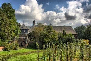 una casa antigua con un jardín delante de ella en Nikolauskloster, en Jüchen