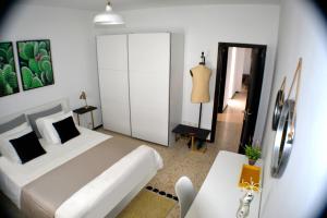 - une chambre avec un grand lit blanc et une table dans l'établissement CASA CALA MAR - TUNERA, à Puerto del Rosario