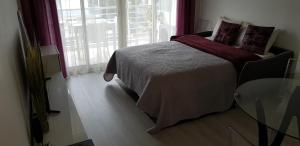 a bedroom with a bed and a glass table at Palm beach Cannes Azur in Cannes