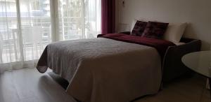 a bedroom with a bed and a window and a table at Palm beach Cannes Azur in Cannes