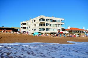 un bâtiment sur la plage avec une foule de gens dans l'établissement FLATS ON THE BEACH BALCONADA I, à La Paloma