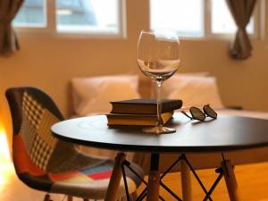 a table with a wine glass and books on it at SKYLER GUEST HOUSE in Plovdiv
