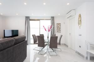 a living room with a couch and a table with chairs at Portofino Resort in Arona