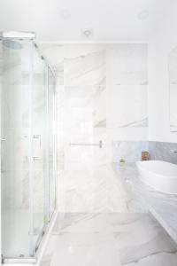 a white bathroom with a shower and a sink at Portofino Resort in Arona