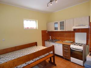 uma pequena cozinha com um banco e um fogão em Csikós Vendégház em Zamárdi