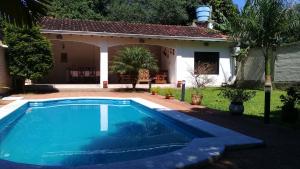 a swimming pool in front of a house at La Esperanza in Piribebuy