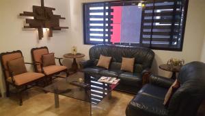 sala de estar con sofá de cuero y sillas en Gervasia Hotel Makati en Manila