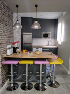 a kitchen with a counter with stools in it at Apartamento centro san blas 36, próximo al Pilar in Zaragoza