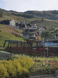 a village on a hill with a fence and houses at Casetta Chamois in Chamois