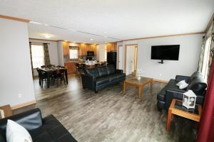 a living room with black leather furniture and a kitchen at Island Club #77 in Put-in-Bay