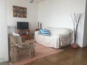 un salon avec un canapé blanc et une télévision dans l'établissement FLATS ON THE BEACH BALCONADA I, à La Paloma