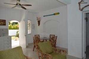 a dining room with a table and chairs and a ceiling fan at Royal Palms Apartment - Sweet Jewel Apartments in Christ Church