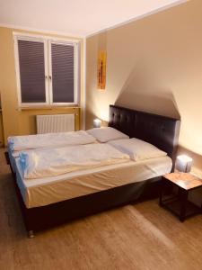 a large bed in a bedroom with two windows at White Pearl Hostel 1 in Nuremberg